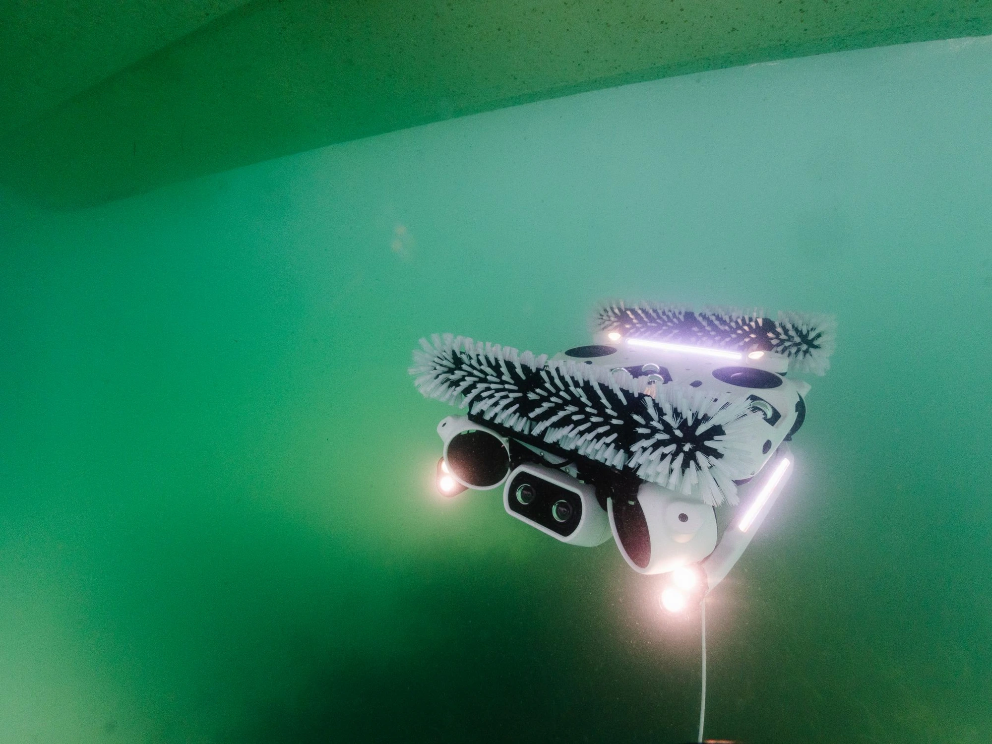 Il robot AirDroneJet in azione sotto la linea di galleggiamento, spazzole e LED accesi